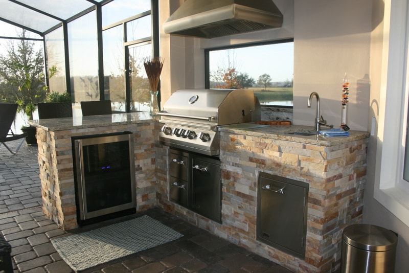 Norstone Aztec Stacked Stone Panels used on the base of an outdoor kitchen in Florida with grill, sink, and fridge